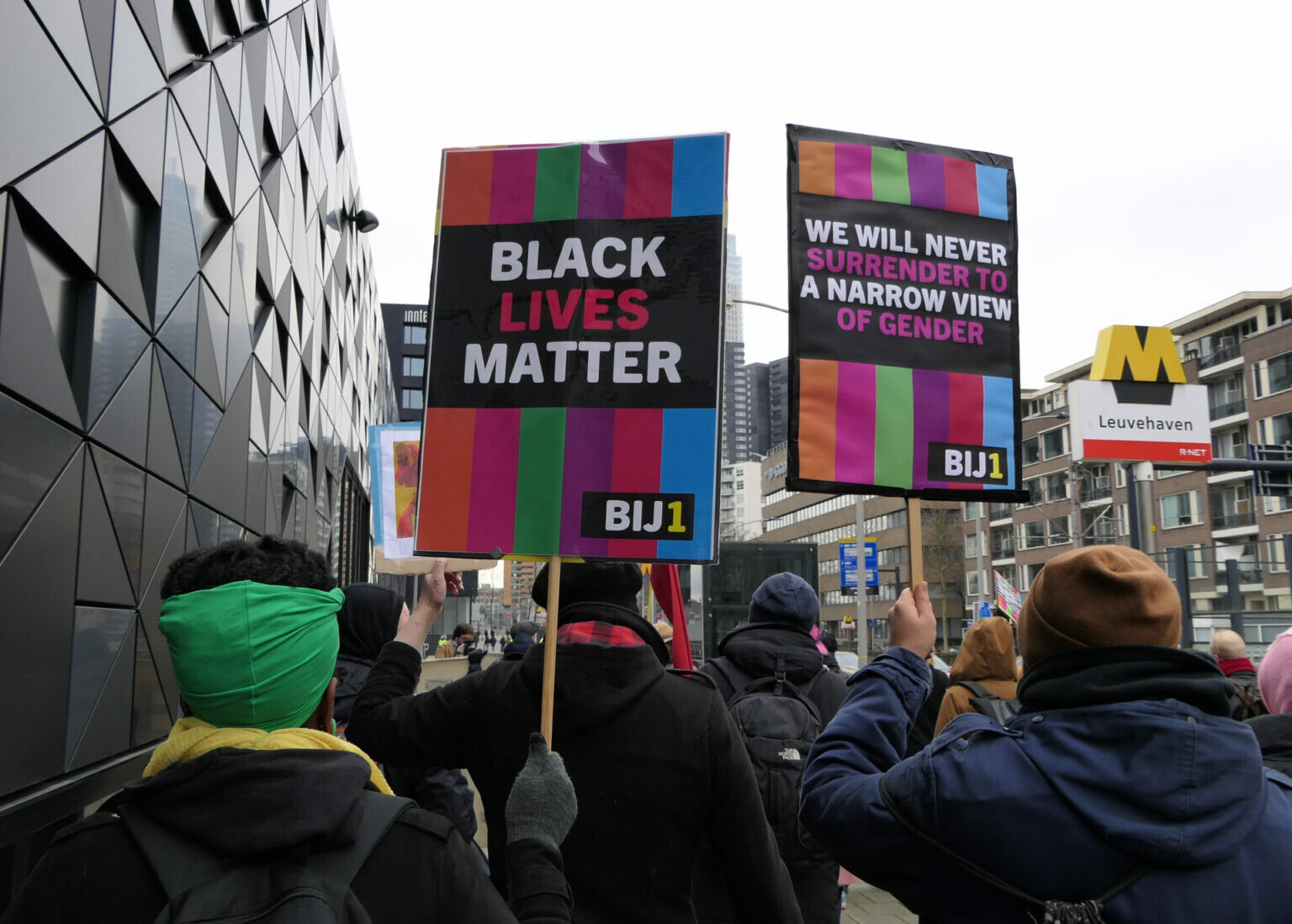 BIJ1-actieborden bij het anti-fascistisch protest van 22 januari in Rotterdam: "Black lives matter en "We will never surrender to a narrow view of gender".