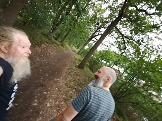 0.6 selfie of regtur (right, lookin to the left) and myself (left, looking to the right) walking on a forest footpath along the Eindhoven canal; less than 10km to Weverijmuseum.