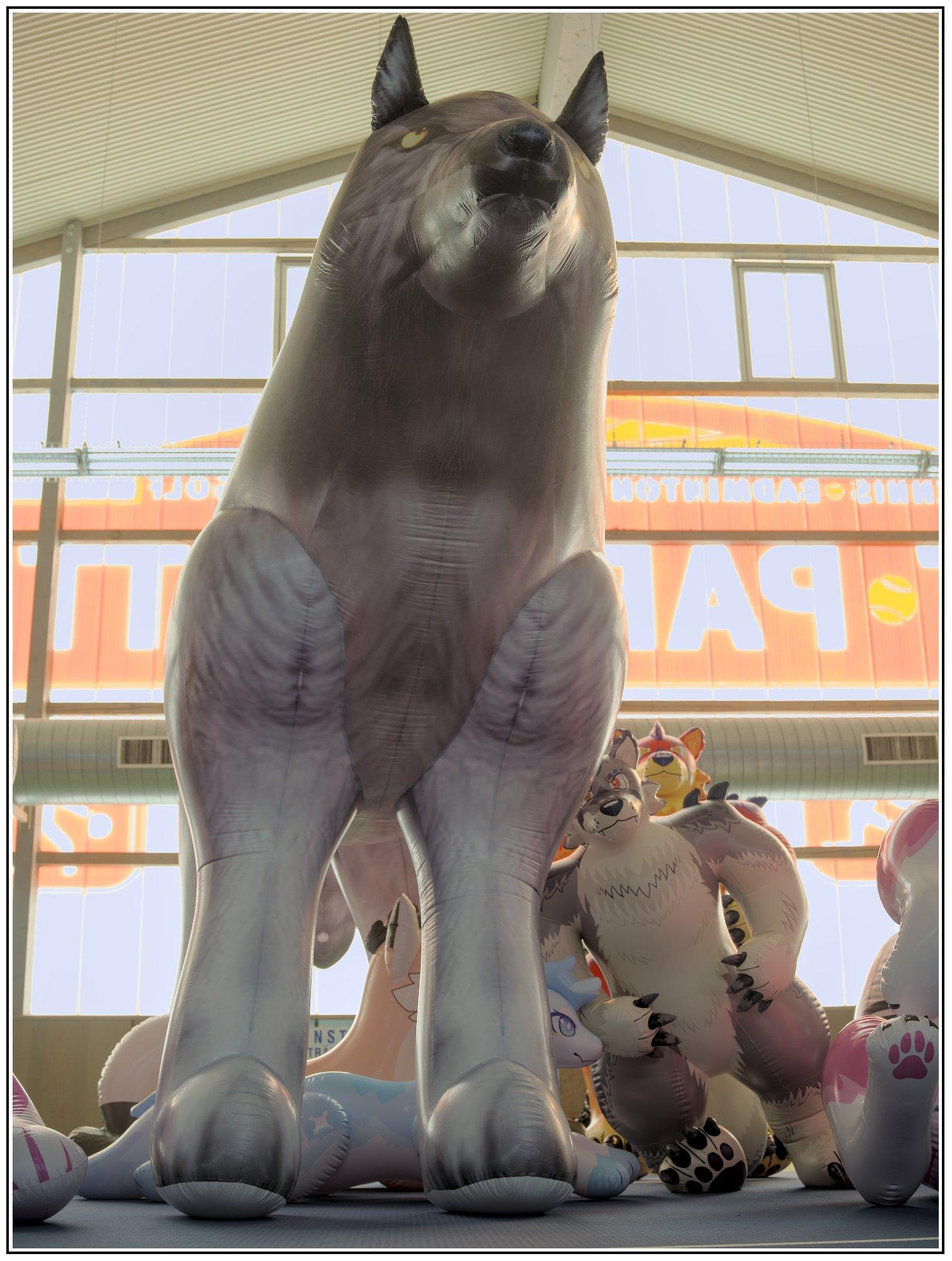 A giant inflatable wolf towering over the photographer and other toys next to it